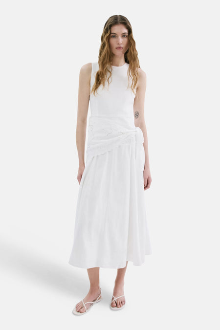Robe sans manches écru de MANGO avec panneau brodé autour de la taille, vu de dos avec des sandales.