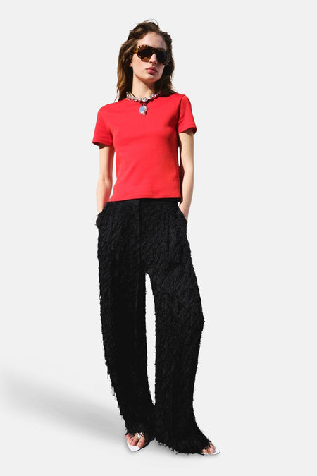 T-shirt rouge de MANGO à manches courtes, porté par un mannequin avec un pantalon à texture noire.