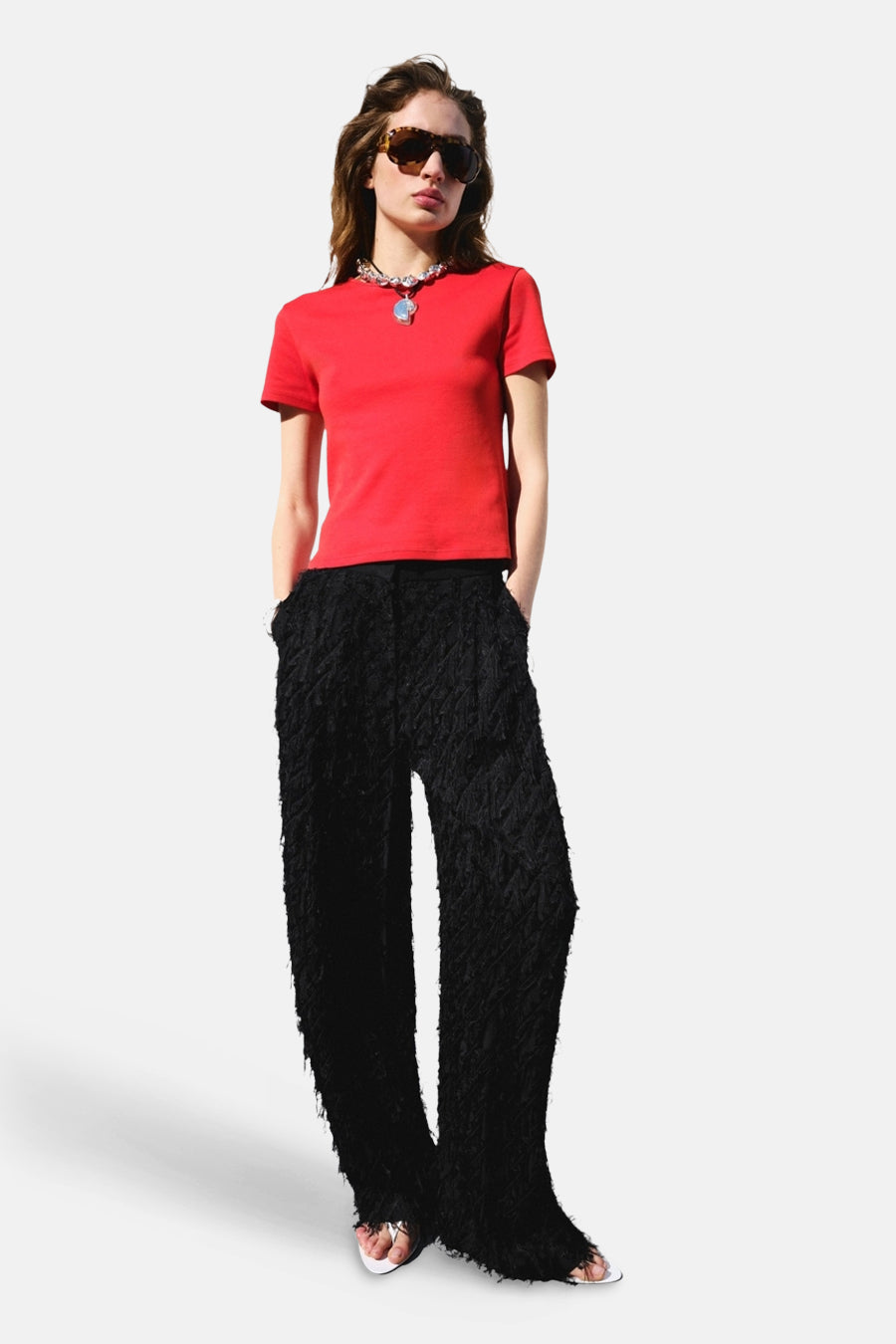 T-shirt rouge de MANGO à manches courtes, porté par un mannequin avec un pantalon à texture noire.