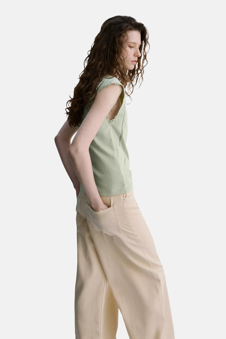 Groene mouwloze top van MANGO, zijwaarts, met geborduurde zoom en lichte stof, gedragen met crèmekleurige wijde broek