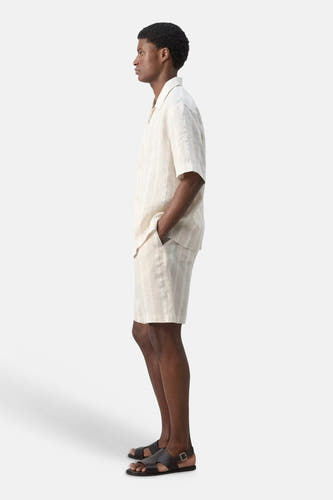 Chemise beige à manches courtes de MANGO, rayée, avec col ouvert et short assorti, vue de côté.