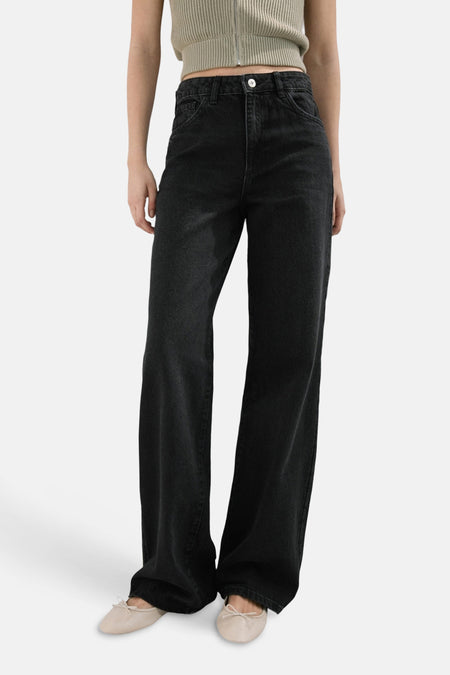 Donkergrijze straight jeans van MANGO, met een hoge taille en losse pijpen, gecombineerd met beige ballerina's en een gebreide top.