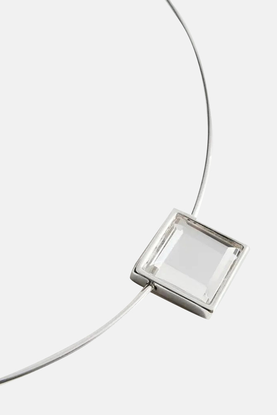 Collier court couleur argent de MANGO, avec un détail de cristal rectangulaire comme pendentif.