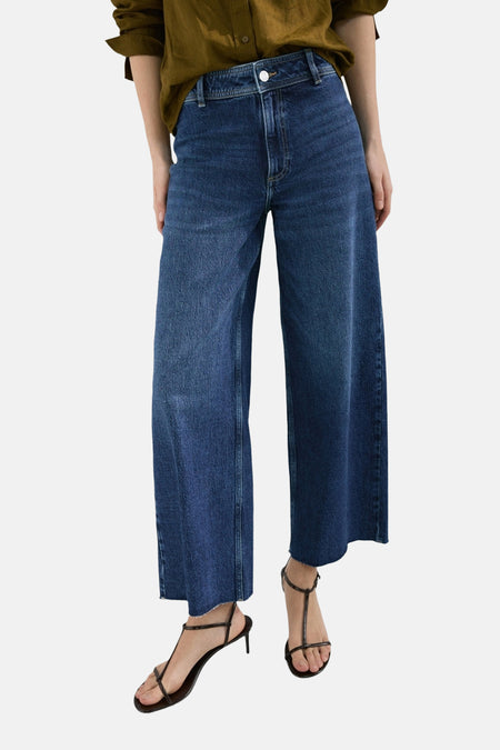 Blauw denim jeans met wijde pijpen van MANGO, gecombineerd met bruine sandalen en een kaki blouse.
