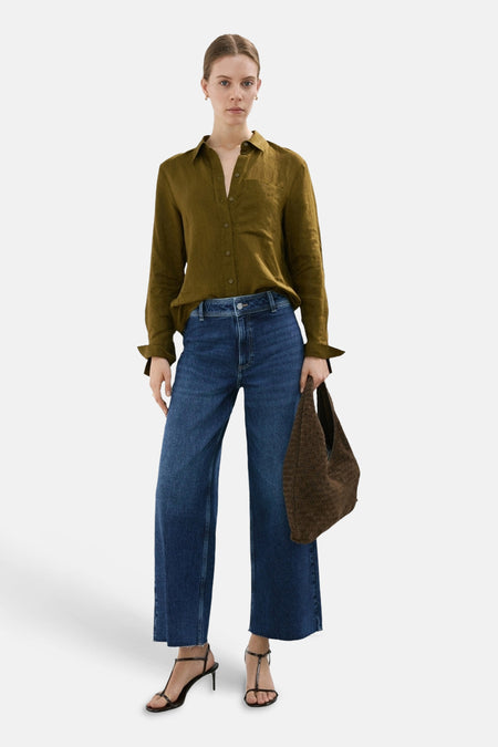 Blauwe CATHERIN jeans wide van MANGO, met een middelhoge taille en wijd uitlopende pijpen, gecombineerd met zwarte hakken.