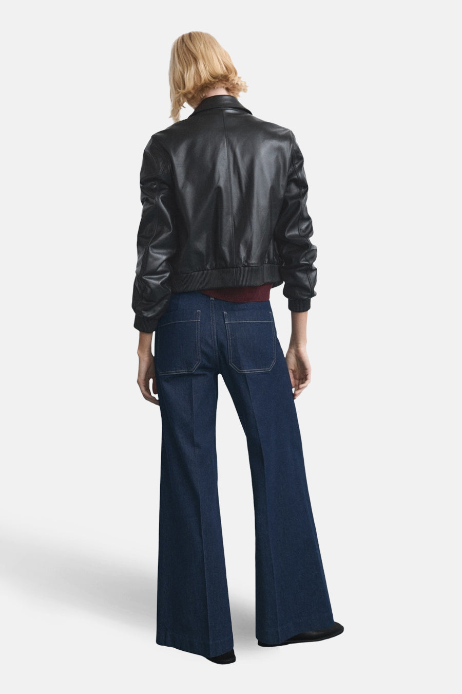 Wijde donkerblauwe jeans van denim van MANGO, gezien van achteren, met wijde pijpen en opgestikte zakken.