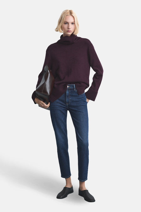 Jean mom bleu marine de denim de MANGO, associé à une veste bordeaux et des chaussures noires.