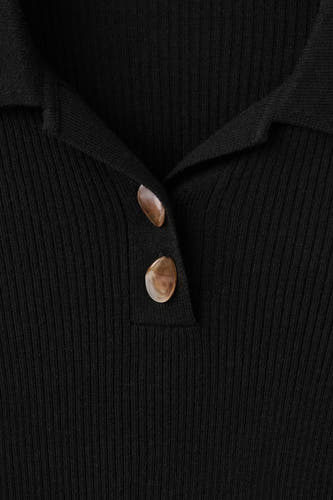 Sweat-shirt noir à col rond de MANGO, avec une texture côtelée et des boutons décoratifs.