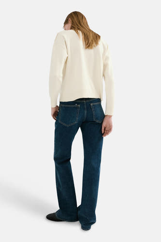 Ecrukleurige trui met ronde hals van MANGO, met lange mouwen, gecombineerd met blauwe jeans.