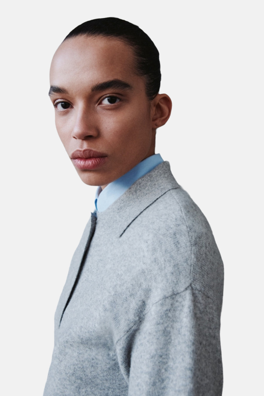 Sweat-shirt gris avec col rond de MANGO, porté sur une chemise bleu clair, gros plan.