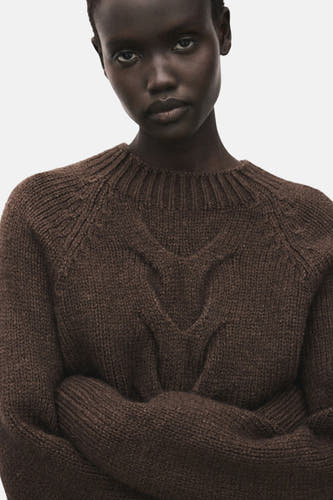 Pull marron avec col rond de MANGO, avec motif côtelé sur la poitrine et manches croisées.