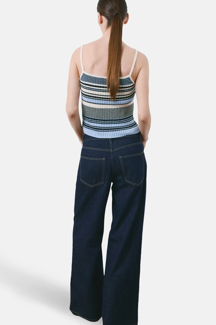 Multicolor top met spaghettibandjes van MANGO, met horizontale strepen in blauw, zwart en wit, gedragen met wijde donkerblauwe jeans.