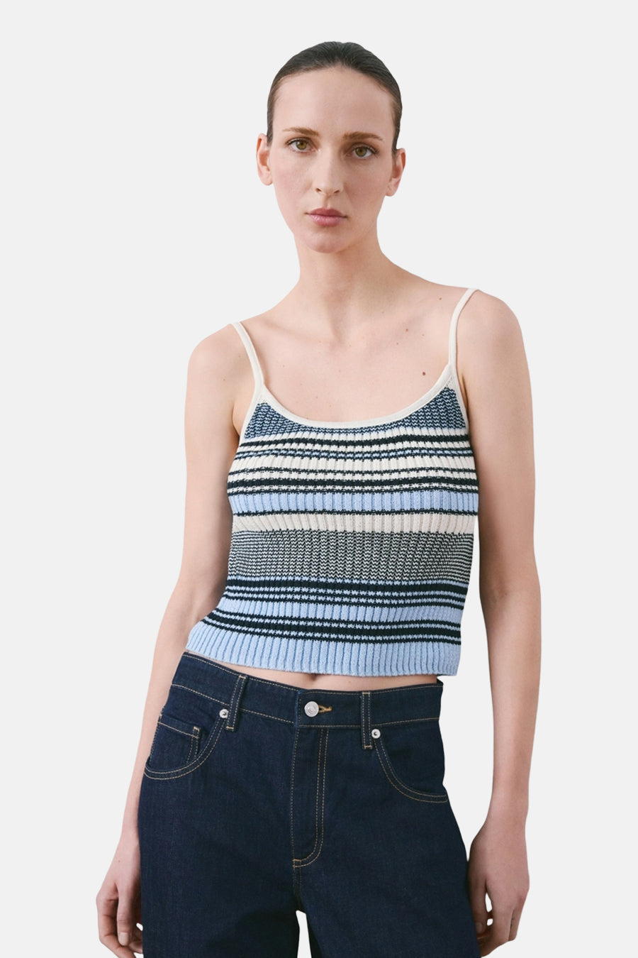 Multicolor spaghettitop van MANGO, met horizontale strepen in blauwe, zwarte en witte tinten, gecombineerd met een donkerblauwe jeans.