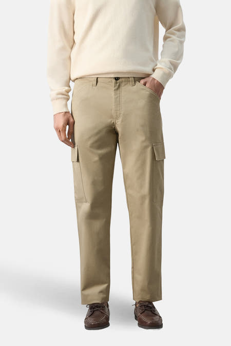 Beige broek van MANGO, gedragen met een crèmekleurige trui en bruine schoenen.
