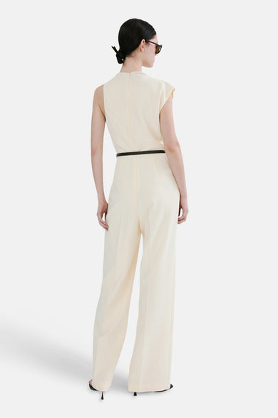 Combinaison écru de MANGO, avec une ceinture noire et des jambes larges, vue de dos.