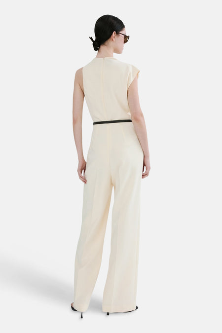 Combinaison écru de MANGO, avec une ceinture noire et des jambes larges, vue de dos.