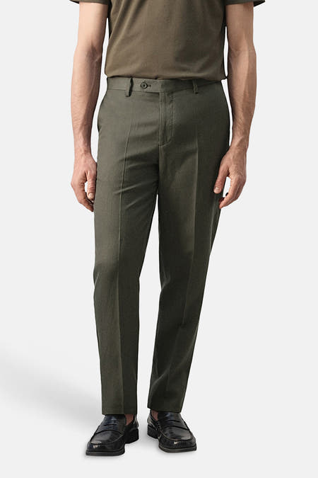 Pantalon kaki de MANGO, vu de dos, avec poches italiennes et chaussures habillées.