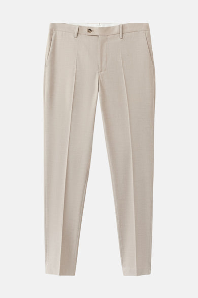 Pantalon de costume beige de MANGO, avec un tissu lisse et des plis marqués.