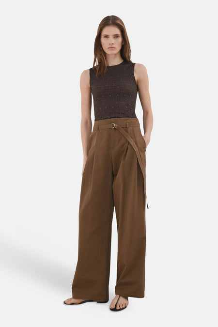 Haut sans manches marron de MANGO avec tissu texturé et subtil scintillement, porté avec un pantalon marron ample.
