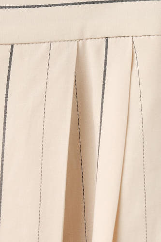 Pantalon écru de MANGO avec rayures craie et plis, gros plan.