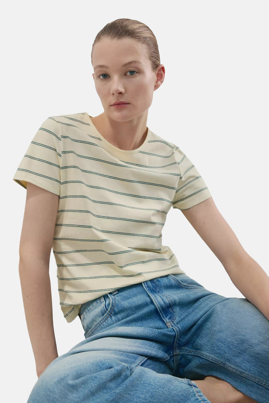 T-shirt jaune clair de MANGO à manches courtes et rayures vertes, vu de dos sur un mannequin portant un jean bleu.