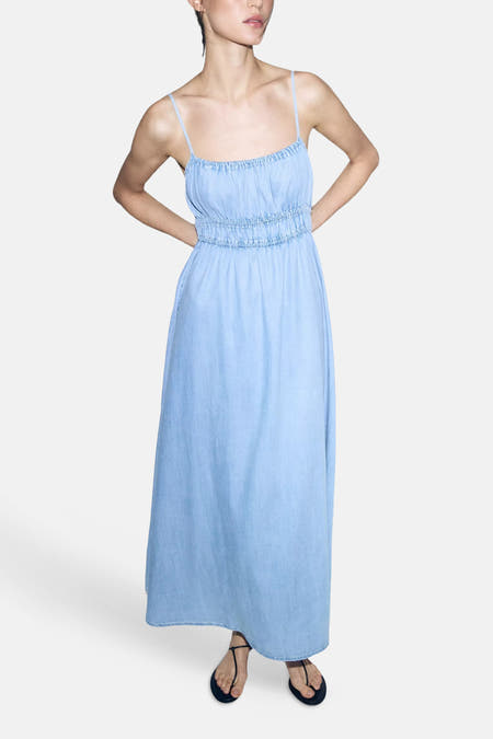 Lichtblauw denimkleedje zonder mouwen van MANGO, met smalle bandjes en elastische taille, volledige lengte, model in front view met zwarte sandalen