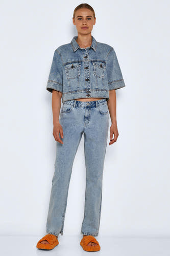 Jean droit en denim bleu clair de Noisy May, avec une fente à la taille, associé à un blouson en denim et des chaussons orange.