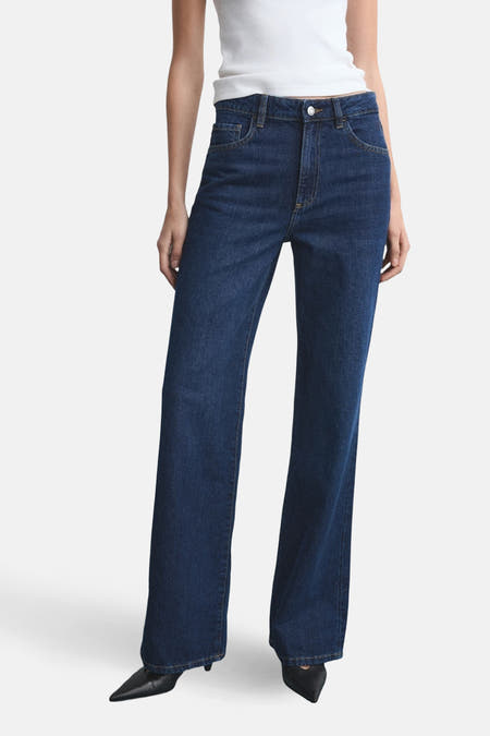 Jean droit en denim bleu marine de MANGO, vu de l'arrière, associé à un chemisier blanc.