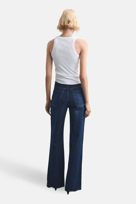 Rechte jeans van donkerblauw denim van MANGO, achterkant gezien, gecombineerd met een wit hemdje.