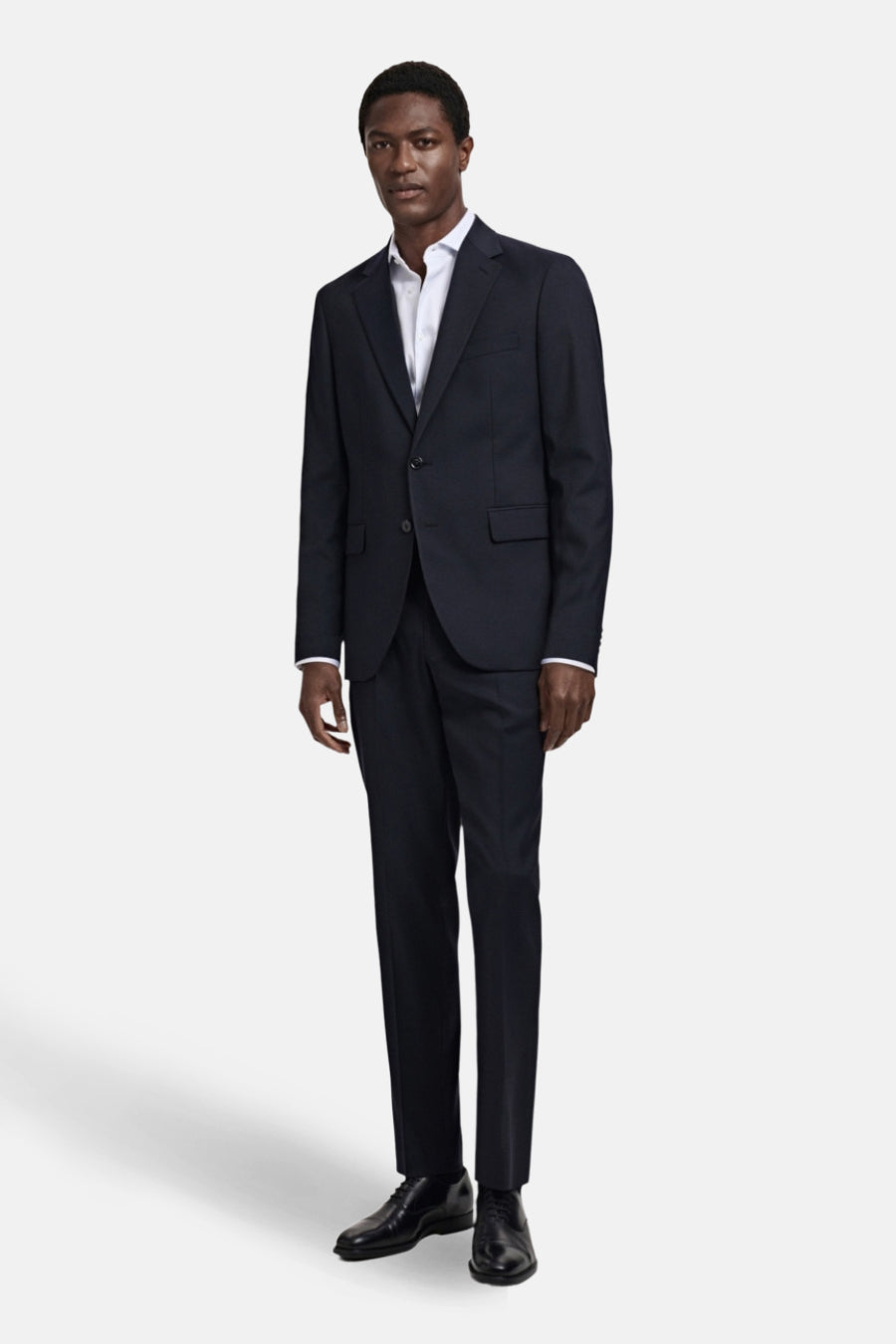 Man in blauw pak en leren schoenen.
