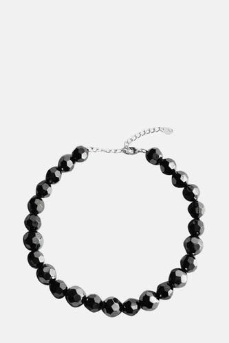 Collier court et noir de MANGO avec fermoir argenté et perles facettées.