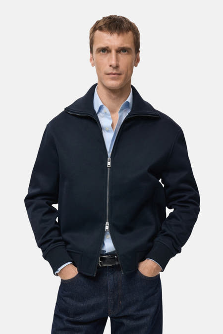Gilet bleu de MANGO, vu d' dosrière, combiné avec un jeans bleu marine.