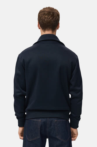 Blauw gilet van MANGO, gezien van achteren, gecombineerd met een donkerblauwe jeans.