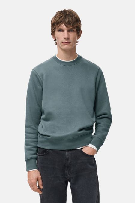 Pull-over bleu avec col rond de MANGO, vu de dos, associé à des jeans foncés.