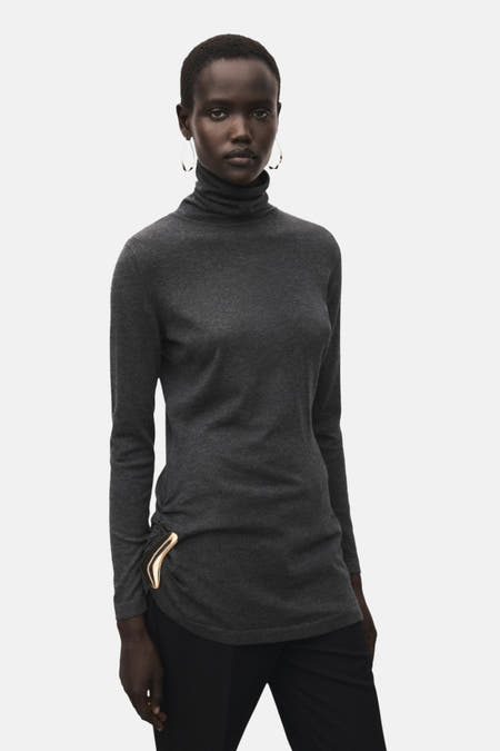Manteau gris de MANGO, avec des manches longues et un détail de fermeture éclair doré, vu de dos.
