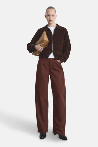 Jeanonine MANGO, avec des jambes large large, associé à une veste brune, un t-shirt blanc et un sac camel.