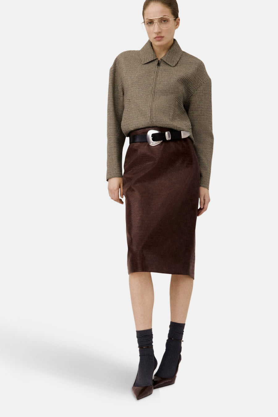 Blazer multicolore de MANGO, avec un motif à carreaux, porté avec une jupe brune en texture de peau de crocodile.