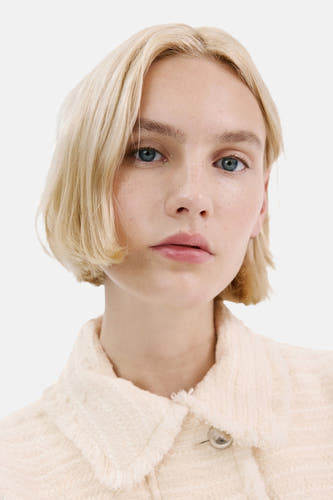 Blazer écru de MANGO, en tissu texturé et une fermeture à un seul bouton.