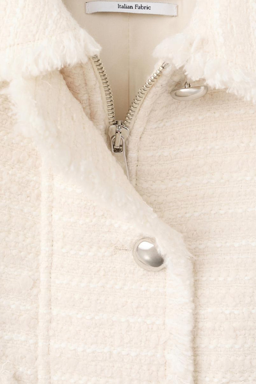 Ecrukleurig jasje van Italiaanse stof met rits en knopen.
