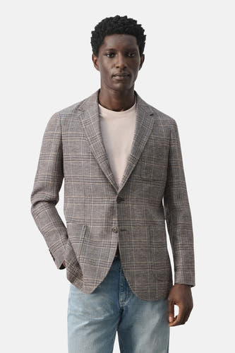 Blazer multicolore de MANGO, avec un motif à carreaux subtil et des manches longues, combinée avec un jean.