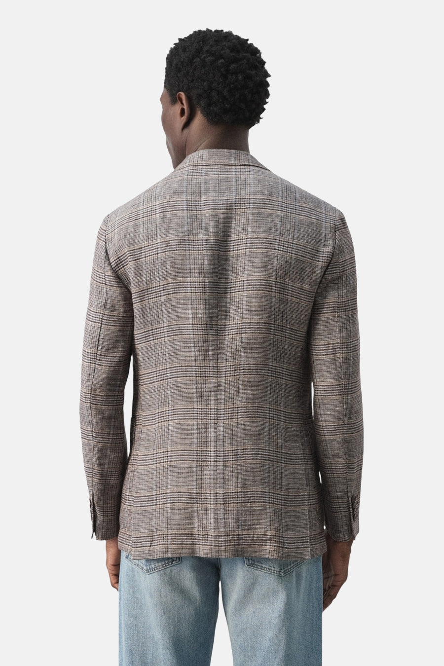Multikleurige blazer van MANGO, met een subtiel ruitpatroon en lange mouwen, gecombineerd met een spijkerbroek.