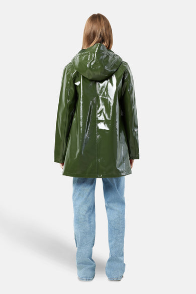 Veste de pluie verte de DROPLETS, avec des manches longues et un capuchon, associée à un jean bleu.