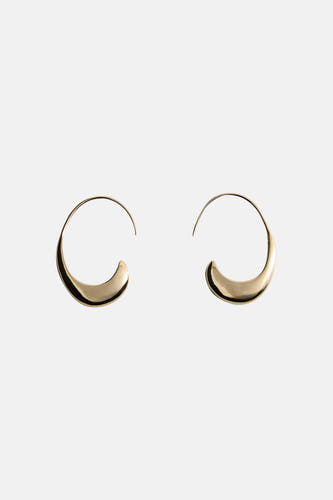 Boucles d'oreilles dorées de MANGO, brillantes et plus épaisses en bas, sur un fond clair.