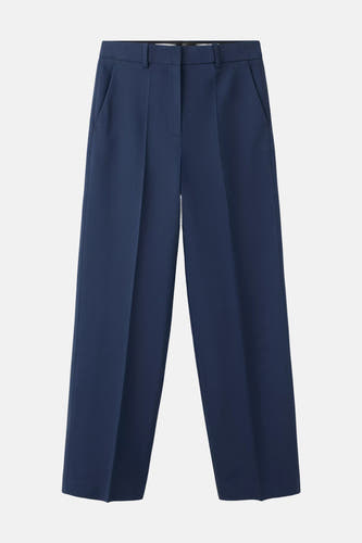 Pantalon de costume bleu de MANGO avec plis, poches latérales et coupe ample, posé à plat.