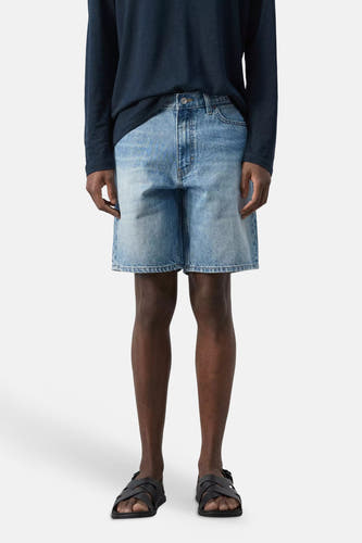 Bermuda en denim bleu moyen de MANGO, gros plan sur la poche avant avec rivets couleur bronze et coutures.