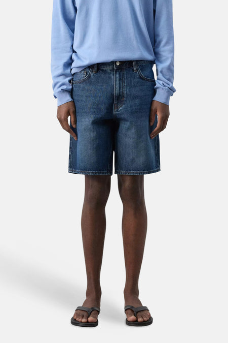 Bermuda en denim bleu marine de MANGO, dos, avec poches plaquées et patch en cuir marron.