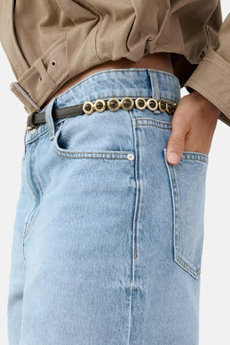 Bermuda en jean bleu clair de MANGO, stylé avec une ceinture à anneaux dorés et un haut court beige.