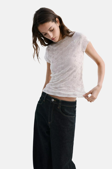 Beige ribbel t-shirt van MANGO, gedragen door model met donkere jeans, zijwaarts geknipt, lichte textuur, korte mouwen