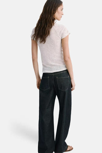 Beige korte mouwen t-shirt van MANGO, ribbelstructuur, zacht geweven, model van achteren, met donkere wijde jeans