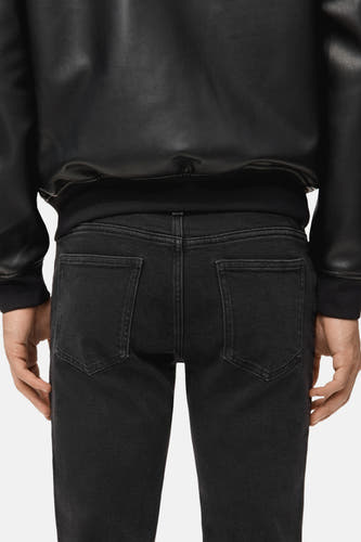 Jean slim fit gris anthracite de MANGO, avec des poches arrière et une subtile texture.